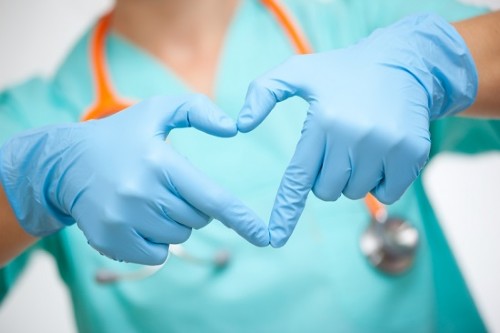 A nurse making a heart with her hands